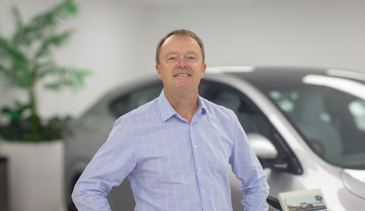 Richard field isolated portrait fleet manager for XPENG standing in XPENG dealer.